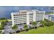 Exterior of a beachfront condominium complex featuring palm trees and stunning water views at 1500 Park Beach Cir # 2F, Punta Gorda, FL 33950
