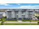 Exterior shot of a multi-story condo building with a rooftop pool and lush landscaping at 1500 Park Beach Cir # 2F, Punta Gorda, FL 33950