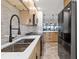 Modern kitchen with stainless steel sink, black appliances, and open design leading into living area at 1500 Park Beach Cir # 2F, Punta Gorda, FL 33950