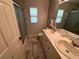 Bathroom featuring double sink, marble flooring, and tiled shower with sliding glass door at 1505 Kenmore St, Port Charlotte, FL 33952