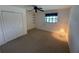 Spacious bedroom featuring a large closet, ceiling fan, and soft carpet floors at 1505 Kenmore St, Port Charlotte, FL 33952