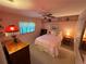 Comfortable bedroom with a ceiling fan, a window and a queen bed is bathed in a warm glow at 1505 Kenmore St, Port Charlotte, FL 33952