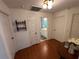 Hallway with wood floors leads to the bathroom, and features display shelves for decorative items at 1505 Kenmore St, Port Charlotte, FL 33952