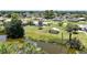 Aerial view of a property with a pond on a tree lined street at 1596 Hayworth Rd, Port Charlotte, FL 33952