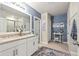 Elegant bathroom with a double sink vanity, granite countertop, and stylish blue-themed decor for a spa-like experience at 16032 Galiano Ct, Punta Gorda, FL 33955