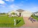Charming single-story home featuring a well-manicured lawn and lovely landscaping with colorful flowers and palm trees at 16032 Galiano Ct, Punta Gorda, FL 33955