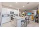 This kitchen includes white cabinets, stainless steel appliances, and an island with barstool seating at 16032 Galiano Ct, Punta Gorda, FL 33955