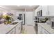 A kitchen with stainless steel appliances, white cabinets, and a view to the living room at 16032 Galiano Ct, Punta Gorda, FL 33955