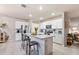 An open kitchen with white cabinets, stainless steel appliances, and an island with barstool seating at 16032 Galiano Ct, Punta Gorda, FL 33955