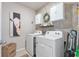 Well-organized laundry room with modern washer, dryer, stylish wallpaper, and functional storage cabinets at 16032 Galiano Ct, Punta Gorda, FL 33955