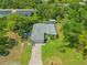 Aerial view of house with gray roof, large yard, driveway and mature landscaping at 17396 Cox Ave, Port Charlotte, FL 33948