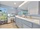 Bathroom with double sinks, white countertops, blue cabinets with gold hardware and tiled floor at 17396 Cox Ave, Port Charlotte, FL 33948