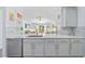 Bright kitchen showcases quartz counters, mosaic backsplash, and seamless flow to living area at 17396 Cox Ave, Port Charlotte, FL 33948