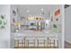 Modern kitchen featuring a breakfast bar with white stools and stainless steel appliances at 17396 Cox Ave, Port Charlotte, FL 33948