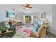Spacious living room with light wood flooring, a ceiling fan, and plenty of comfortable seating at 17396 Cox Ave, Port Charlotte, FL 33948