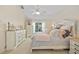 Bright main bedroom with white dressers, ceiling fan, carpet flooring and sliding glass doors to lanai at 17396 Cox Ave, Port Charlotte, FL 33948