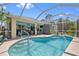 Screened-in pool with views of the lanai, outdoor seating area and tropical landscaping at 17396 Cox Ave, Port Charlotte, FL 33948