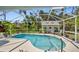 Screened-in pool with view of the backyard and guest house in the background at 17396 Cox Ave, Port Charlotte, FL 33948