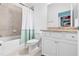 Well-lit bathroom featuring shower and tub combination, white vanity, and walk in closet at 17629 Palmetto Pass Ln, Punta Gorda, FL 33982