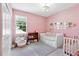 Sweet pink bedroom with a daybed, crib, and decorative shelves for a  at 17629 Palmetto Pass Ln, Punta Gorda, FL 33982