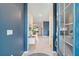 Bright home entryway with blue accent wall and view into adjacent living area with tile flooring at 17629 Palmetto Pass Ln, Punta Gorda, FL 33982
