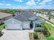 Inviting one-story home showcasing a neatly landscaped yard, brick paver driveway, and a two-car garage at 17629 Palmetto Pass Ln, Punta Gorda, FL 33982