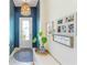 Light-filled foyer with white door, blue accent wall, pendant light and decorative artwork at 17629 Palmetto Pass Ln, Punta Gorda, FL 33982