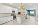 Open kitchen with white cabinets, granite countertops, stainless appliances, and a kitchen island at 17629 Palmetto Pass Ln, Punta Gorda, FL 33982