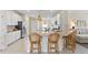 Modern kitchen with white cabinetry, granite countertops, island seating and an adjacent living space at 17629 Palmetto Pass Ln, Punta Gorda, FL 33982