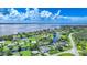 Aerial view showing a waterfront community with canals, lush greenery, and a glimpse of the bay beyond at 192 Danforth S Dr, Port Charlotte, FL 33980