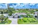 Aerial view of property featuring waterfront canal access, private pool, lush landscaping and a gray roof at 192 Danforth S Dr, Port Charlotte, FL 33980