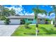 Charming single-story home featuring stone accents, a paved driveway, and lush landscaping with palm trees at 192 Danforth S Dr, Port Charlotte, FL 33980