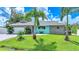 Charming single-story home featuring stone accents, a paved driveway, and lush landscaping with palm trees at 192 Danforth S Dr, Port Charlotte, FL 33980