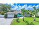 Charming single-story home featuring stone accents, a paved driveway, and lush landscaping with palm trees at 192 Danforth S Dr, Port Charlotte, FL 33980