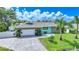 Charming single-story home featuring stone accents, a paved driveway, and lush landscaping with palm trees at 192 Danforth S Dr, Port Charlotte, FL 33980