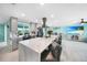 Well-lit kitchen island with bar seating and view of TV and living room with water-themed decor at 192 Danforth S Dr, Port Charlotte, FL 33980