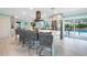 Modern kitchen features a marble waterfall island with seating and an easy transition to the outdoor pool area at 192 Danforth S Dr, Port Charlotte, FL 33980