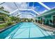 The screened-in pool has chairs, tables and palm trees in the background at 192 Danforth S Dr, Port Charlotte, FL 33980