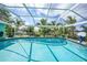 Beautiful screened-in pool with palm trees, blue skies, and a waterfront view at 192 Danforth S Dr, Port Charlotte, FL 33980