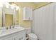Simple bathroom design with a vanity, toilet, cabinet, and shower with a white curtain at 206 Gondola Park Dr # 206, Venice, FL 34292