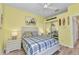 This beach-themed bedroom has yellow walls, coastal decor, and a bed with a plaid comforter at 206 Gondola Park Dr # 206, Venice, FL 34292