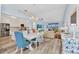 Open-concept dining room with white table, blue chairs, and modern chandelier at 206 Gondola Park Dr # 206, Venice, FL 34292