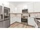Modern kitchen with stainless steel appliances, white cabinets, and quartz countertops at 206 Gondola Park Dr # 206, Venice, FL 34292