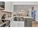 Bright kitchen with stainless steel appliances, white cabinets, and bar top overlooking dining area at 206 Gondola Park Dr # 206, Venice, FL 34292