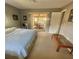 Bright main bedroom featuring a sliding glass door to a sunroom, carpet floors, and neutral paint at 2119 Pellam Blvd, Port Charlotte, FL 33948