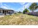 Spacious backyard featuring a fire pit, wood fence and a screened-in patio with outdoor ceiling fan at 2465 Deedra St, Port Charlotte, FL 33952