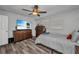 Cozy bedroom with ceiling fan, light walls, wood-look floors, and dresser at 2465 Deedra St, Port Charlotte, FL 33952