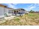 Exterior view of the home with screened-in patio and an attached hose at 2465 Deedra St, Port Charlotte, FL 33952