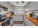 Efficient kitchen featuring gray cabinets, wooden countertops, modern appliances, and vinyl flooring at 2465 Deedra St, Port Charlotte, FL 33952