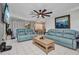 Comfortable living room with tile floors, reclining sofas, ceiling fan, and an open floor plan at 2465 Deedra St, Port Charlotte, FL 33952